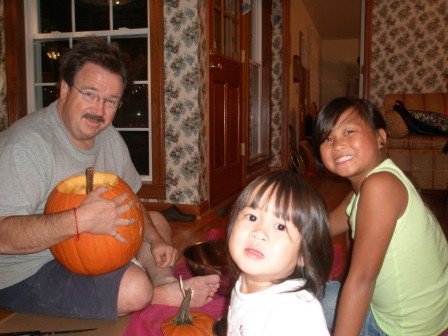 Kasen, Karis and Daddy carving pumpkins